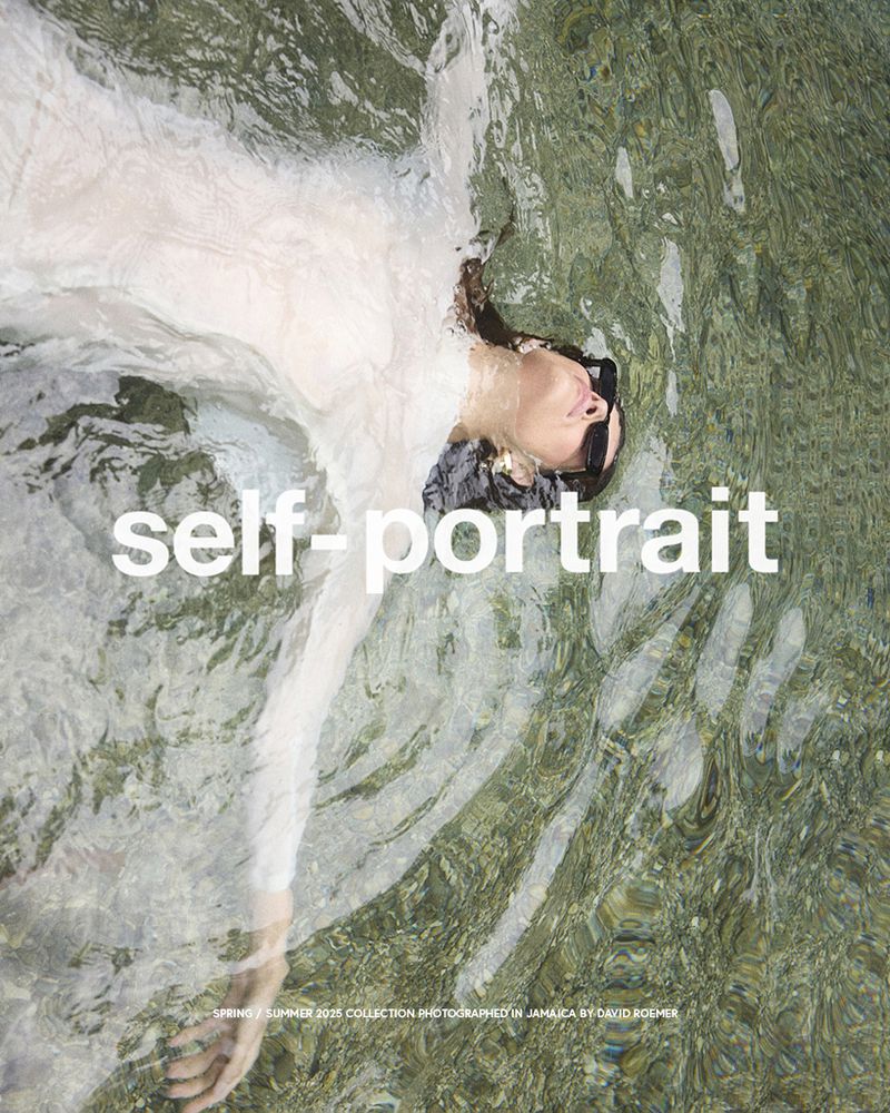 Woman in a sheer dress lies floating on her back in shallow rippling water reflecting sunlight, creating a serene water portrait.