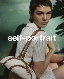 Model wearing white ribbed knit top and holding white leather shoulder bag with brown trim against a green background