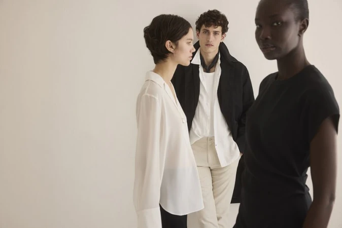 Three fashion models pose in a studio against a white background, showcasing modern apparel and minimalist style in a clean, well-lit setting.