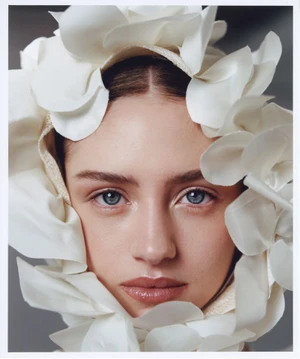 Close-up portrait of model Leni Klum wearing a structured white petal headpiece for Glamour Germany by Agata Serge.