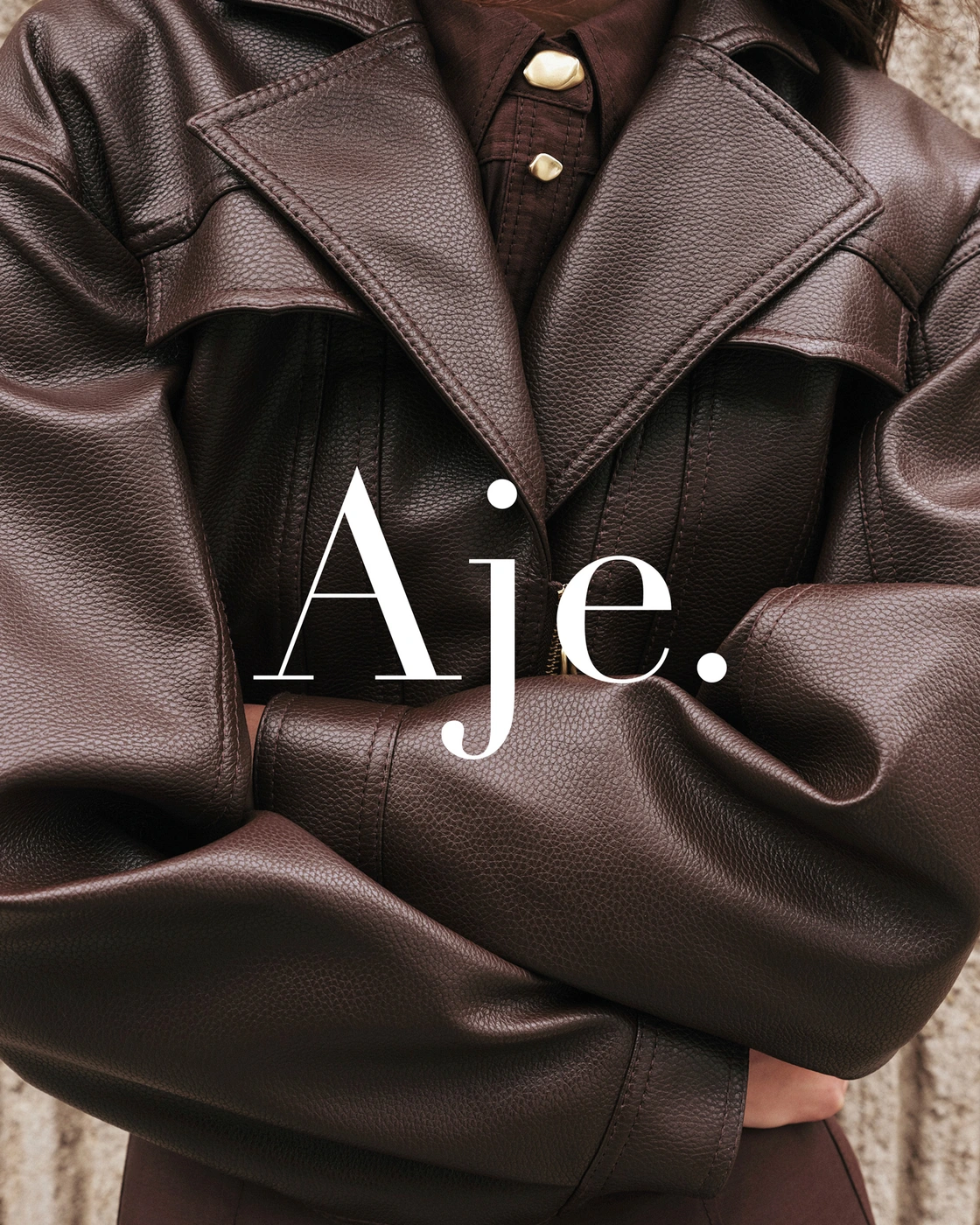 Close-up of white sheer ruched fabric with textured carpet background and bold Aje logo overlay