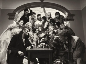 Group of diverse people gathered around a table playing chess under an arched doorway for COAT Magazine Chess Club editorial