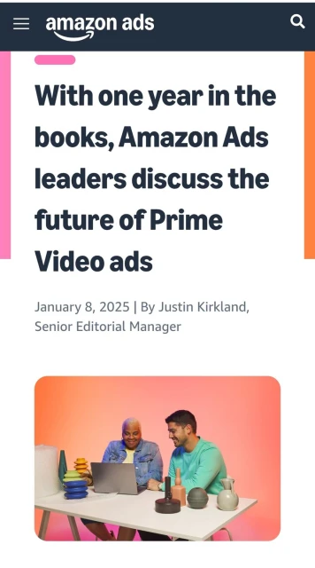 Amazon Ads article image. Two men smiling and looking at a laptop on a desk with various objects, against an orange gradient backdrop.
