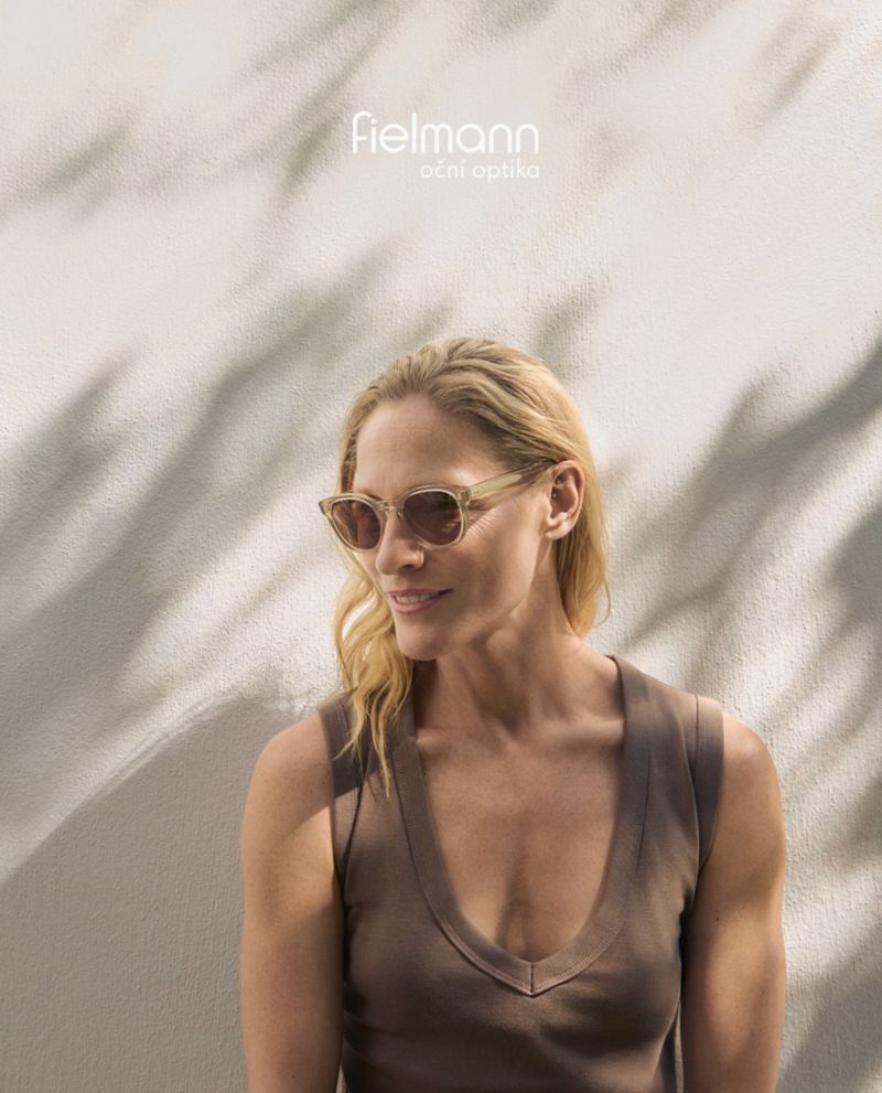 Portrait of a blonde woman in sunglasses, with a neutral top and a leafy shadow behind her; promoting Fielmann eyeglasses.