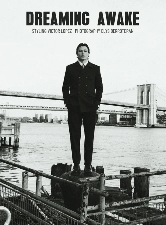 A man in a suit stands on a pier in a black-and-white fashion shot, with the Brooklyn Bridge and city skyline in the background.