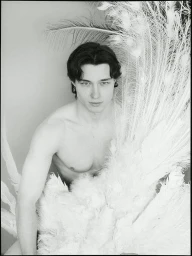 Portrait of a man posing with large white feathers for the Dreaming Awake project by MMScene