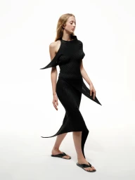 Model wearing a black sculptural dress against a white background for Issey Miyake