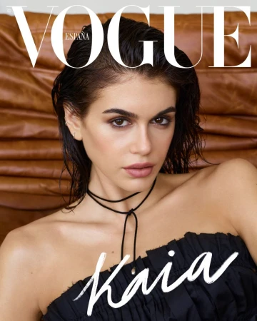 Vogue España cover featuring a portrait of a young woman with wet dark hair and a black top against a warm leather-toned backdrop.