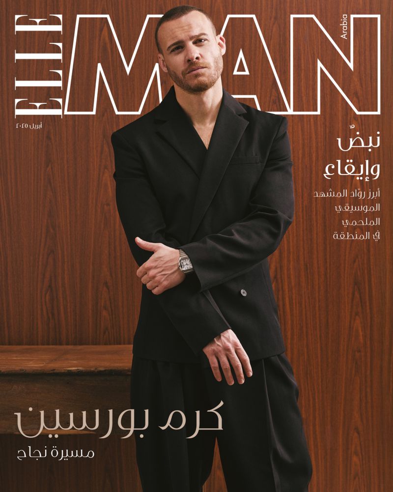 Elle Man Arabia magazine cover featuring an adult male fashion model in a black suit, set against a wood-toned background. 
