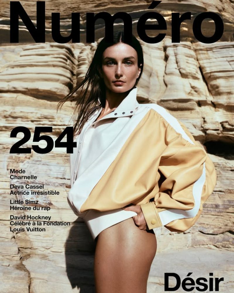 Magazine cover featuring a woman in a white bodysuit and two-tone jacket against a rocky desert landscape with magazine text overlays.