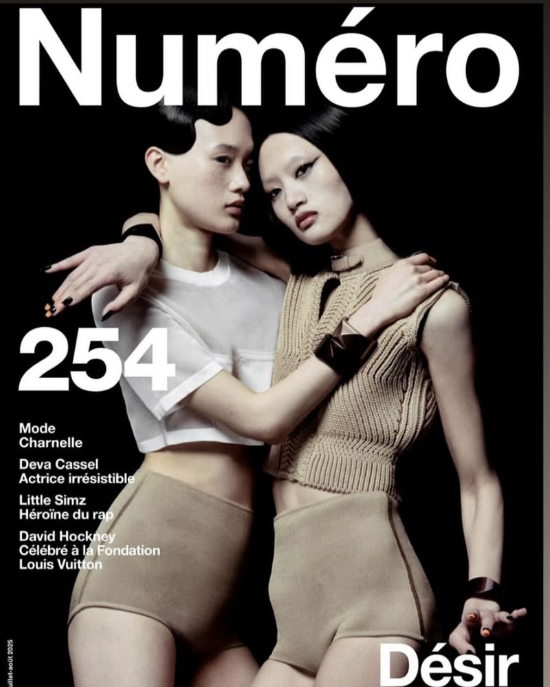 Numéro magazine cover featuring two Asian women models posing in studio with minimalist clothing. Black background, with magazine text overlay.