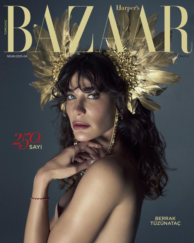 Magazine cover featuring Berrak Tüzünataç wearing a gold feather headdress and jewelry, posing against a dark gray backdrop.