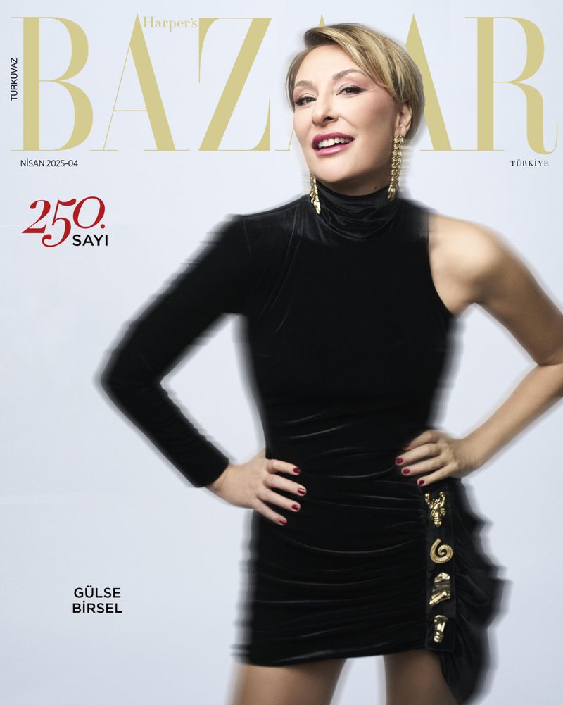 Elegant woman on Harper's Bazaar cover, wearing a black dress and gold earrings, poses confidently against a light background.