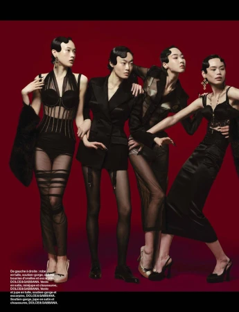 Four women in black Dolce & Gabbana gowns pose in a fashion editorial against a dark red backdrop, exhibiting an elegant vintage aesthetic.