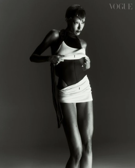 Black and white fashion shot featuring a woman in an abstract bodysuit and wrap in a studio setting for a magazine editorial.