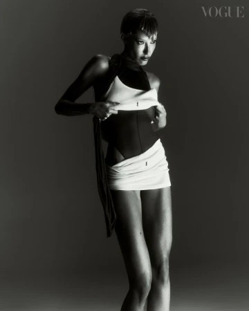 Black and white fashion shot featuring a woman in an abstract bodysuit and wrap in a studio setting for a magazine editorial.
