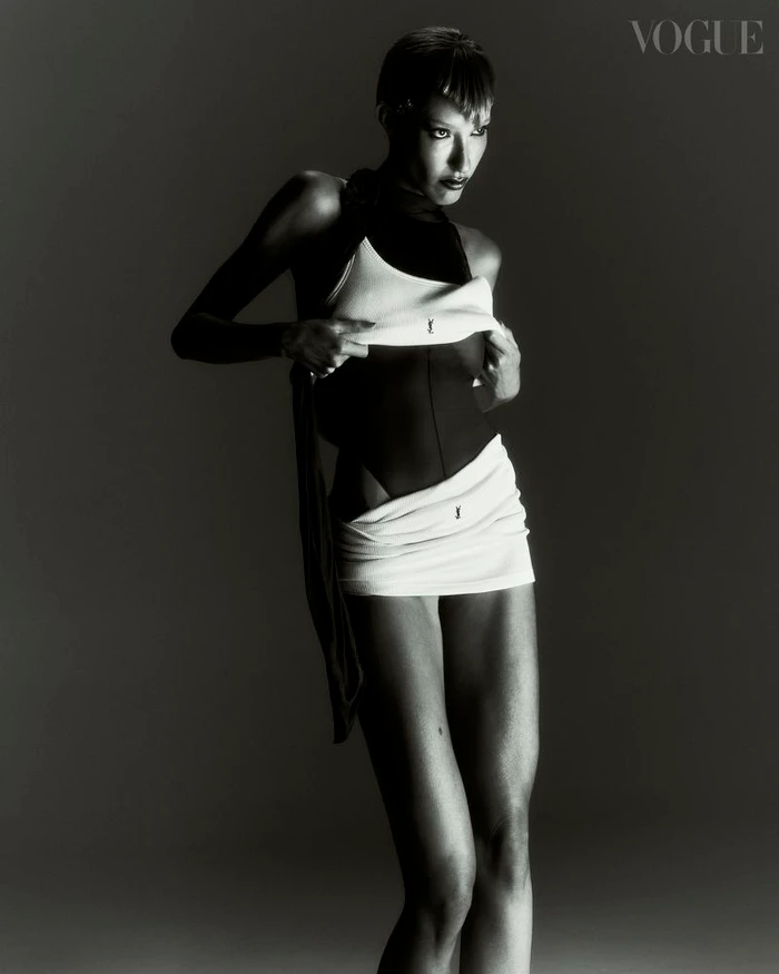 Model in black and white layered swimwear posing against a dark gradient background for Vogue Portugal editorial