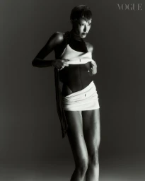 Model in black and white layered swimwear posing against a dark gradient background for Vogue Portugal editorial