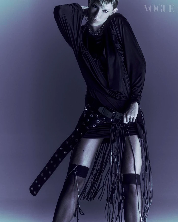 Model in black fringe skirt and dark top posing against a moody background for Vogue Portugal