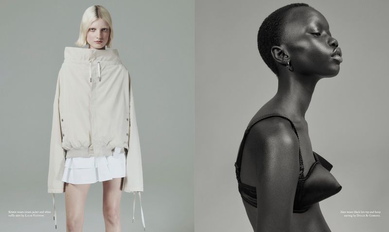 Two female fashion models posing in a gray studio: one in an oversized cream jacket, the other in a black bra with dramatic side lighting.