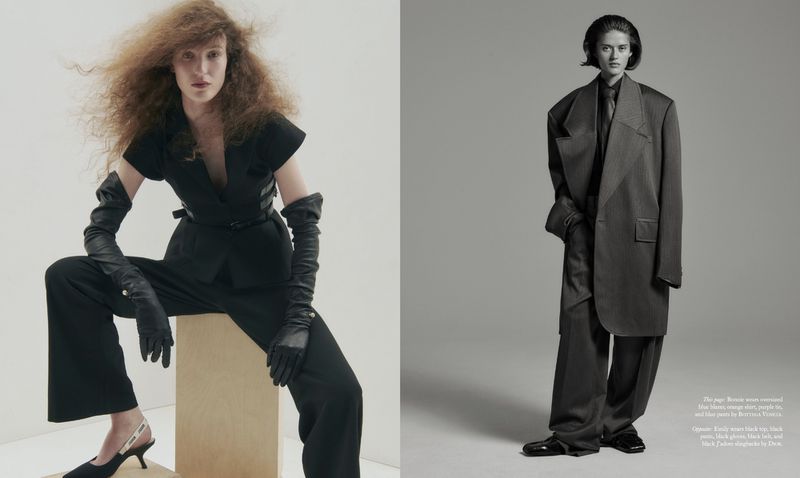 Two women in fashionable dark-colored outfits pose in a photo studio with curly hair, long gloves, and high-heeled shoes.