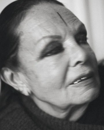 Striking black-and-white portrait of an elderly adult female with intense gaze, emphasizing age and character with detailed facial features.