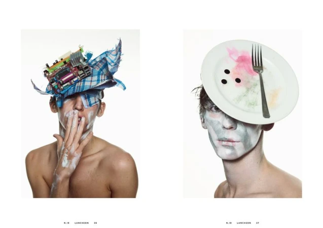 Avant-garde portrait of two young adults with creative makeup and headwear made of fabric, electronic parts, plates, and forks on white.