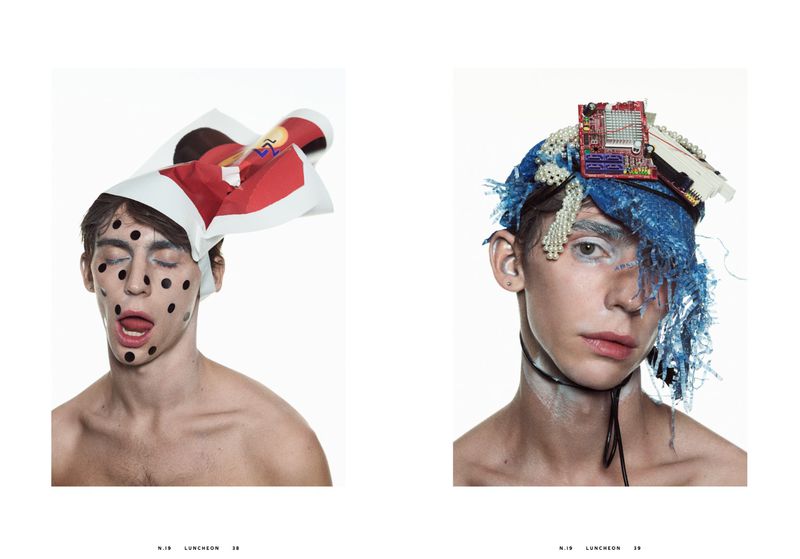 Two young adults are featured in a studio shot, each wearing avant-garde headwear and makeup in a unique fashion and beauty aesthetic.