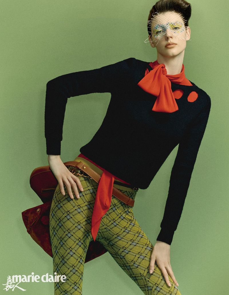 A fashion shot features a stylish woman in green plaid pants, a black sweater with red accents, a brown belt, and a veiled headpiece.