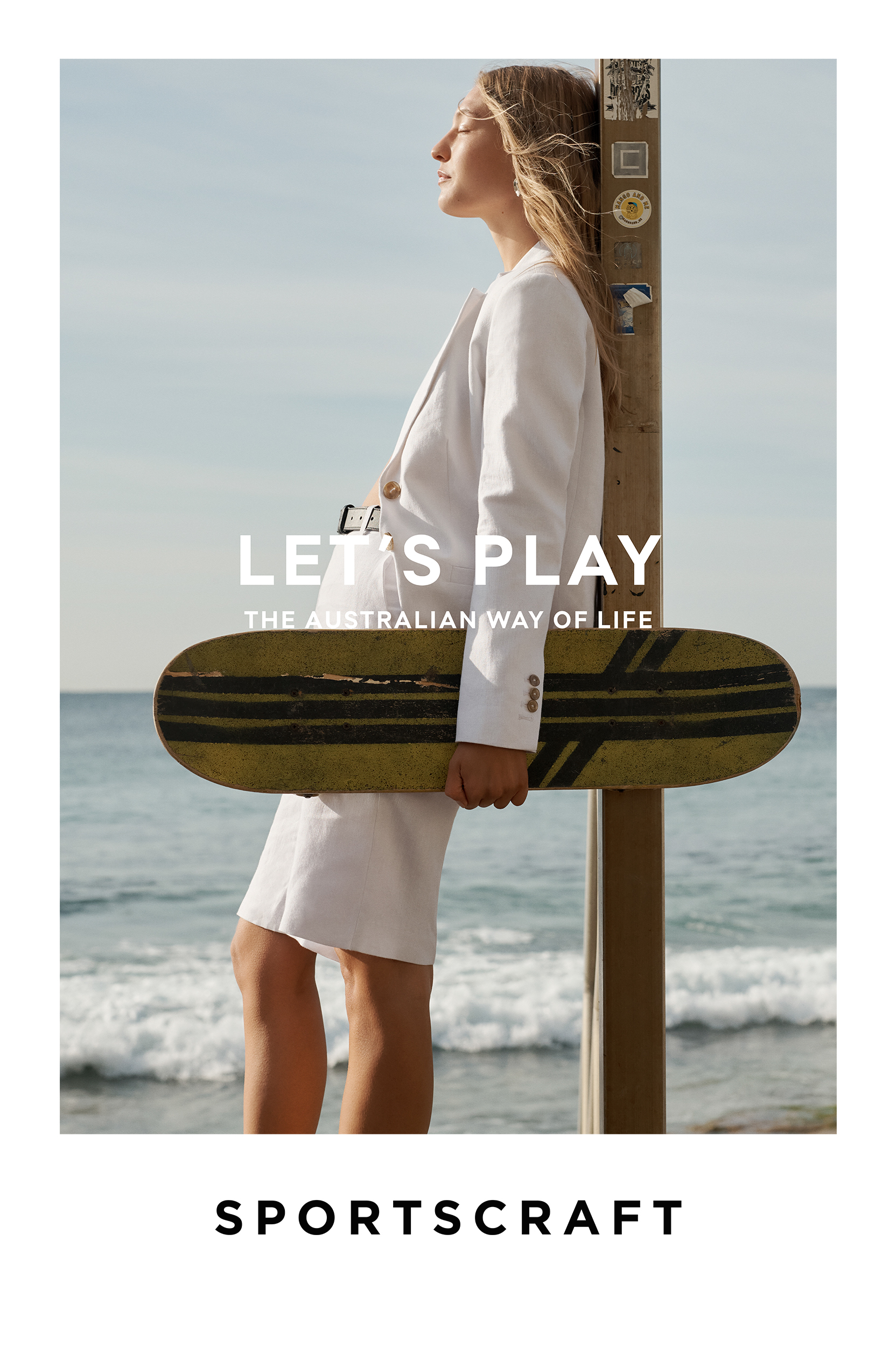 Woman in white suit stands on beach with surfboard. 'LET'S PLAY, THE AUSTRALIAN WAY OF LIFE' text, promoting SPORTSCRAFT brand.