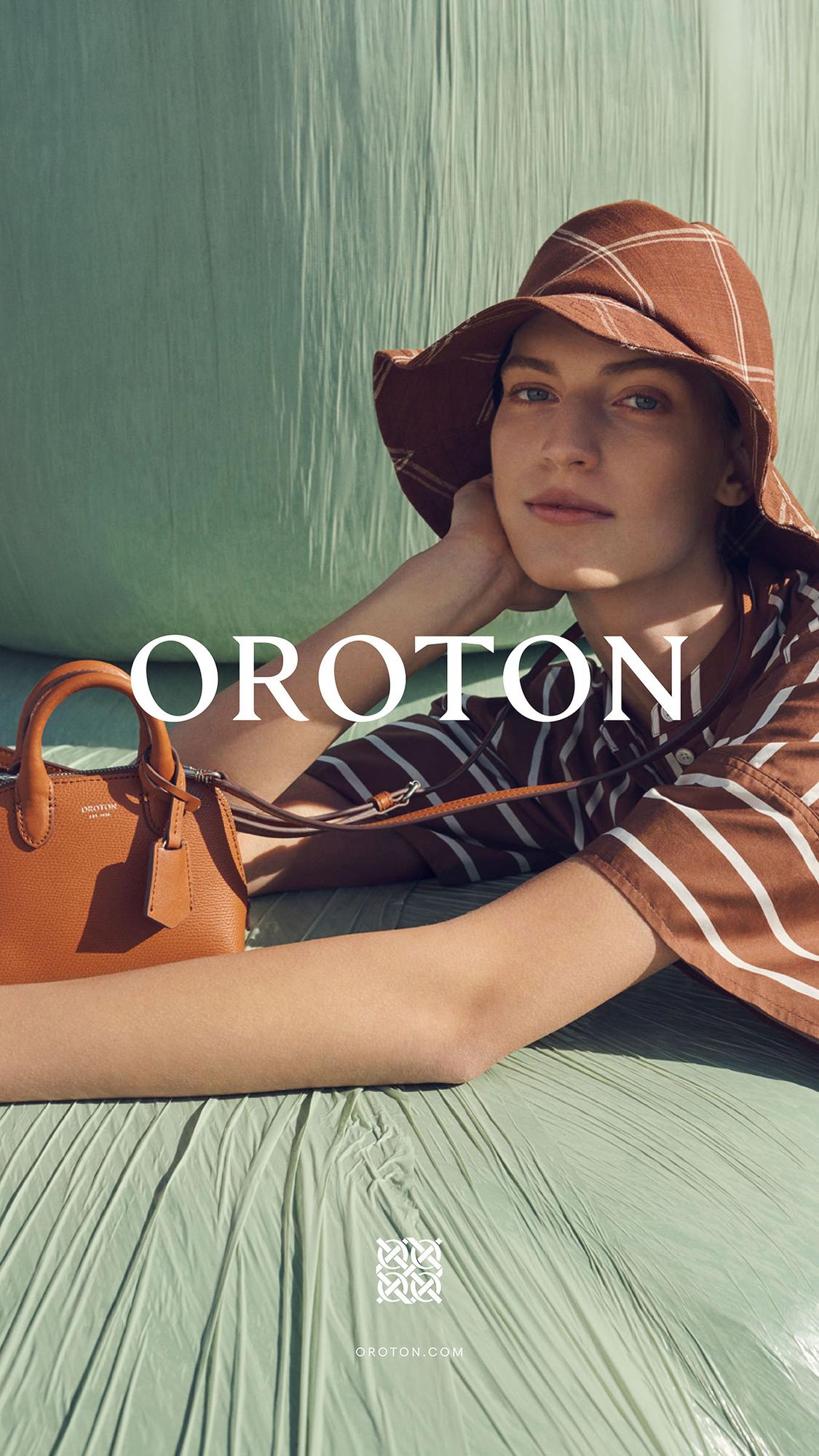 Fashion editorial featuring a woman wearing a striped top and hat, accessorized with a brown leather handbag, against a green backdrop.