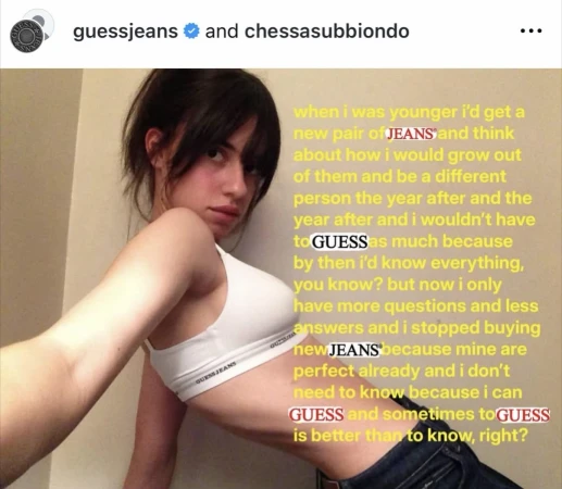 A young woman with dark hair poses indoors wearing a white sports bra and jeans, accented with yellow text from the Guess Jeans brand.