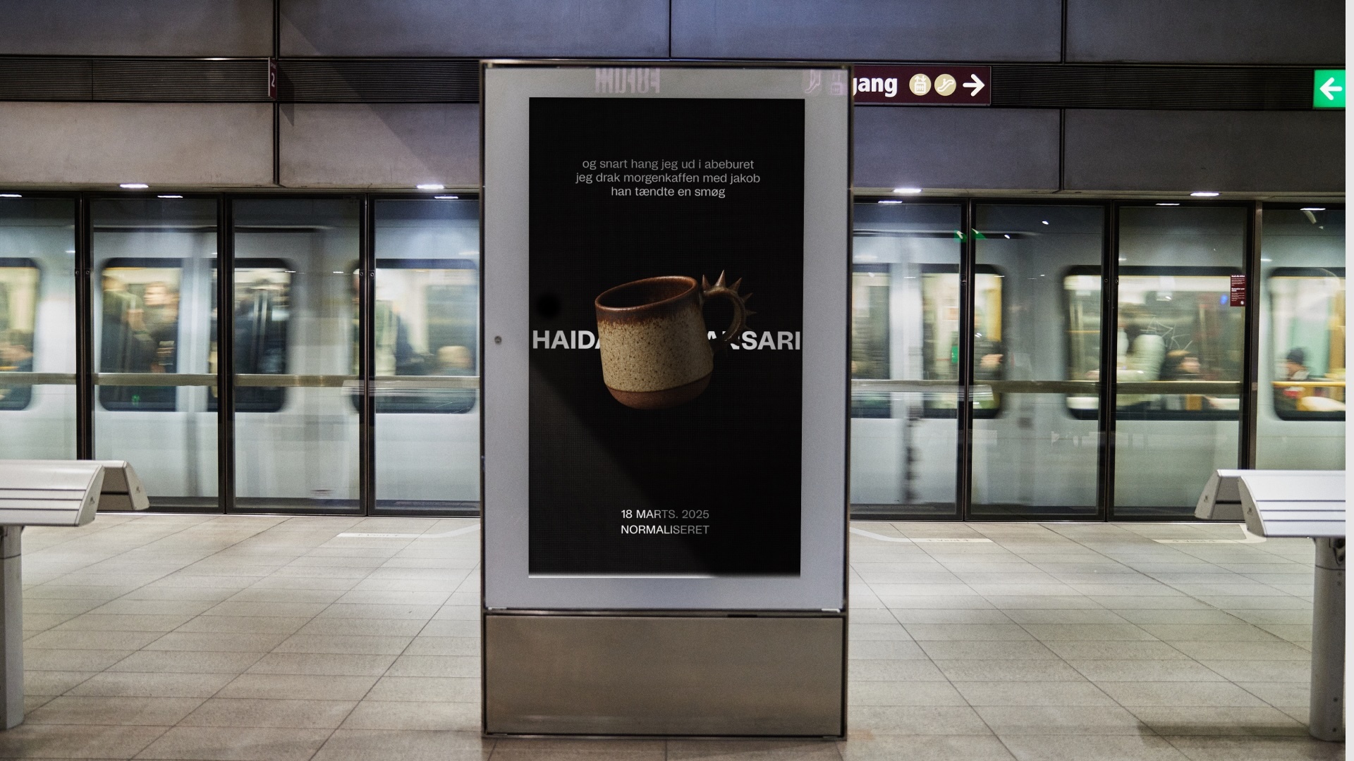 Advertisement in a subway station features a brown ceramic mug on a black background, promoting 'Haid,' with a passing train.