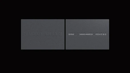 Two dark grey textured business cards displaying debossed branding and typography against a solid black background.