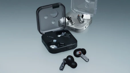 Nothing Ear wireless earbuds and charging cases in black and silver on a smooth grey gradient surface.