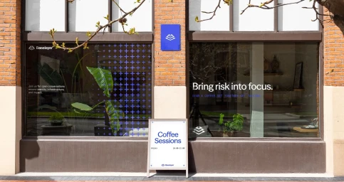 Baselayer brand identity on a brick storefront with large glass windows and an A-frame sidewalk sign reading Coffee Sessions.