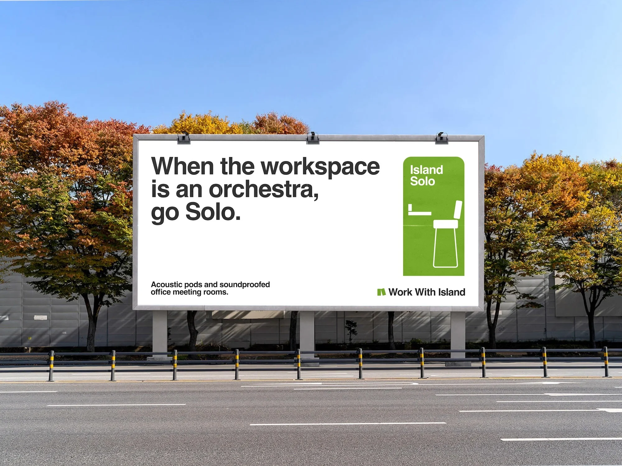 Outdoor billboard advertising soundproofed office meeting rooms by Work With Island, under blue sky with fall foliage trees.