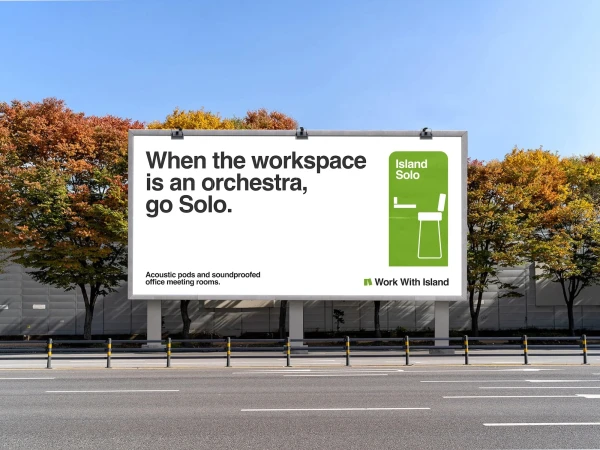 Outdoor billboard advertising soundproofed office meeting rooms by Work With Island, under blue sky with fall foliage trees.