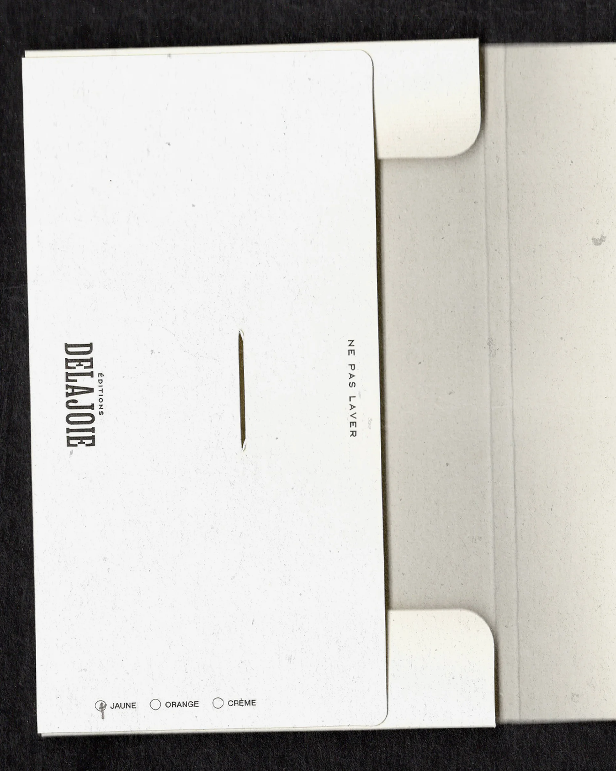 Open white cardstock envelope with printed text and color options, showcasing minimal design on a black background.