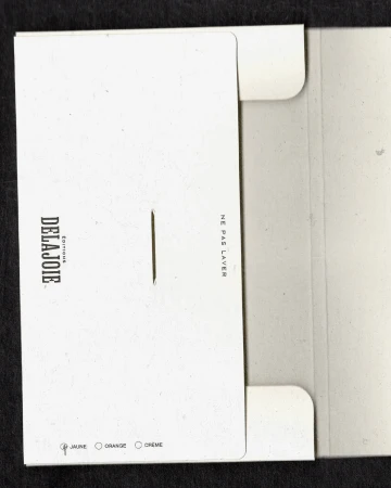 Open white cardstock envelope with printed text and color options, showcasing minimal design on a black background.