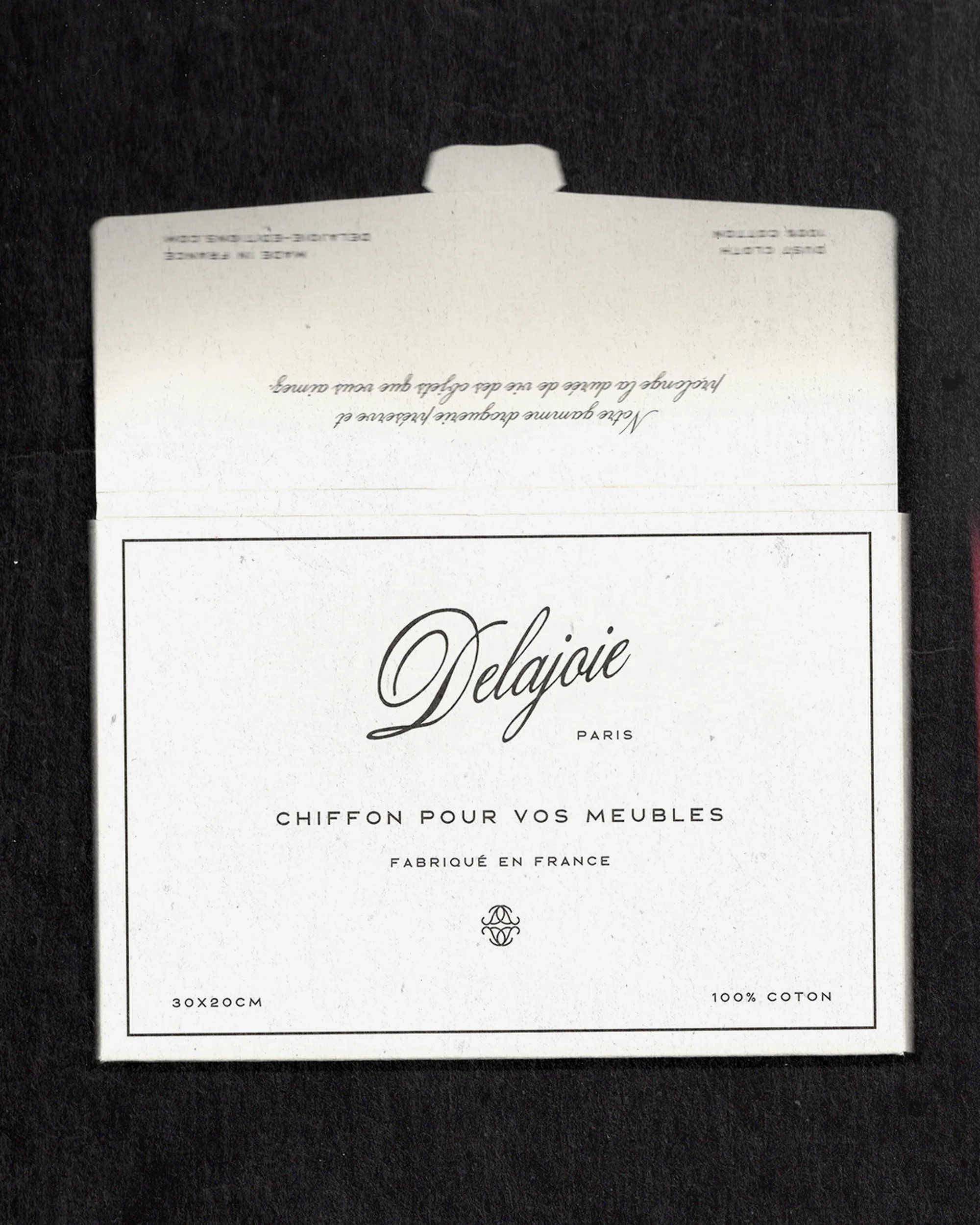 Delajoie Paris furniture cleaning cloth packaging, featuring elegant script logo and French text on a white surface with black backdrop.