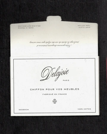 Delajoie Paris furniture cleaning cloth packaging, featuring elegant script logo and French text on a white surface with black backdrop.