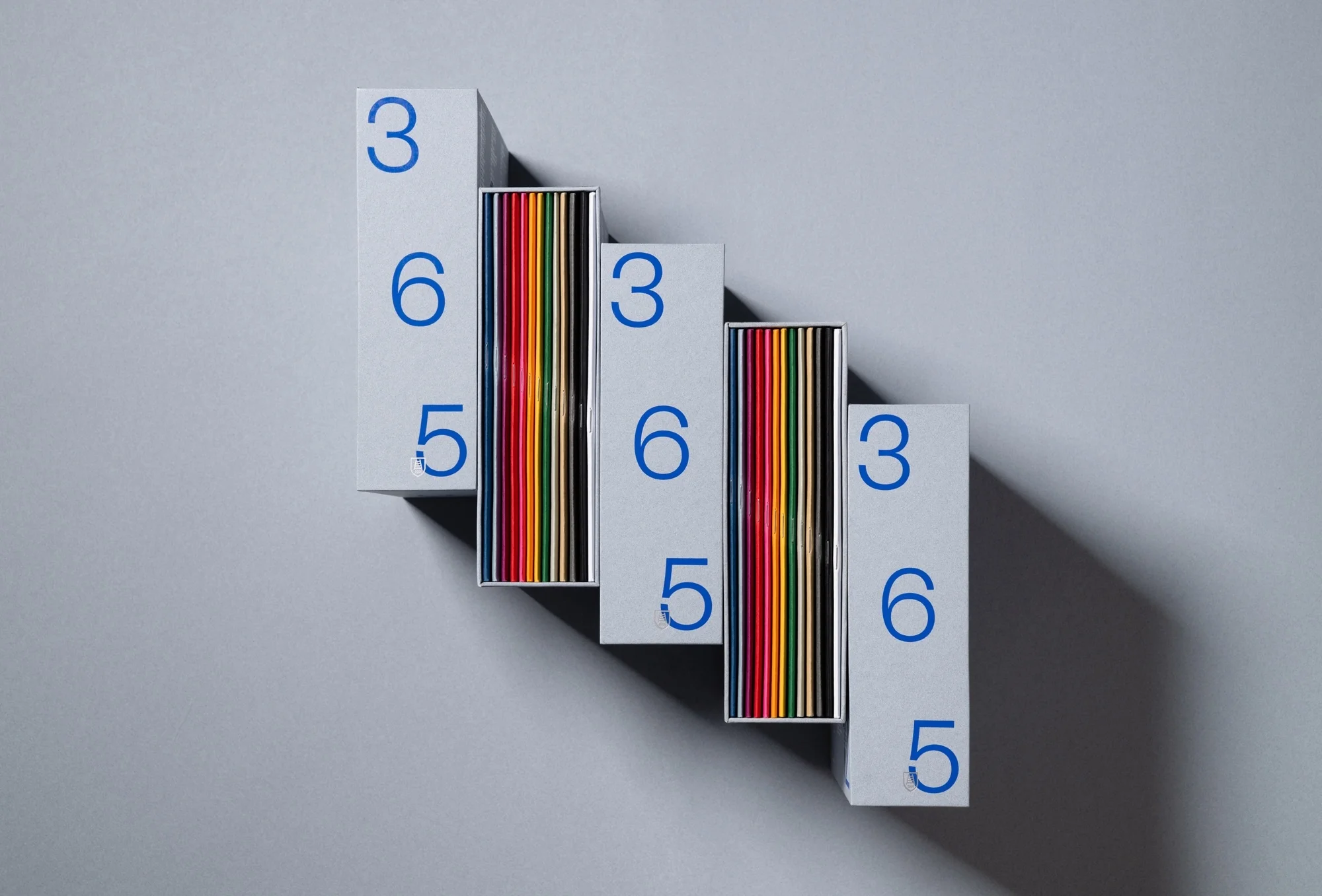 Arrangement of staggered boxes with multicolored objects inside and the numbers 3, 6, and 5 printed in blue against a light gray background.