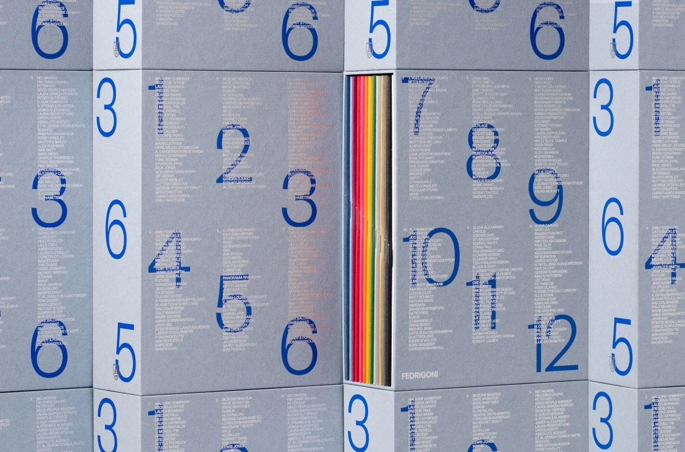 Grey paper packaging boxes with large blue numbers and typography containing colourful spines inside