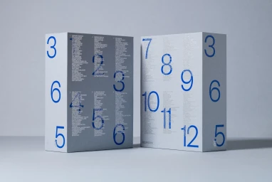 Two grey paper boxes featuring blue typography and numbers displayed on a light surface.