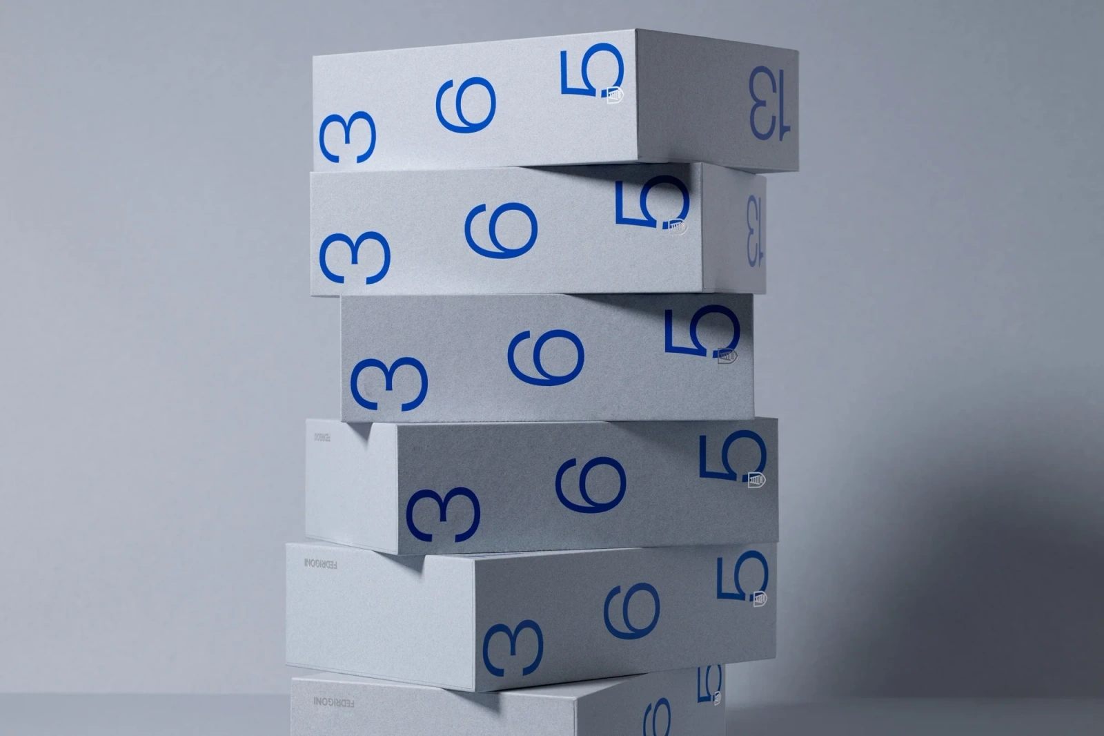 A vertical stack of pale grey custom paper boxes printed with bold blue numbers against a neutral background.
