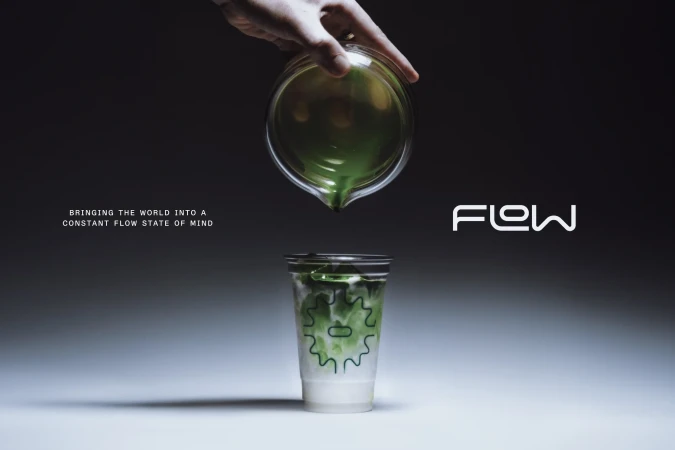 Hand pours green liquid from glass beaker into a plastic cup with logo on gradient gray background in studio product shot.