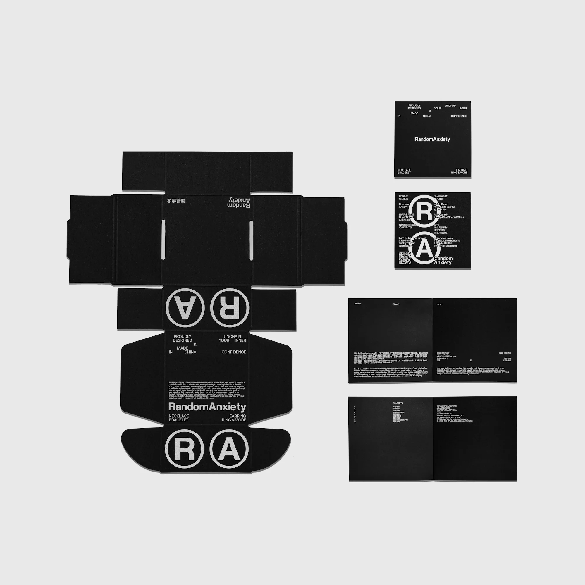 Black and white product photography of RandomAnxiety packaging layout, featuring a box die-cut, cards, and promotional material on a light grey backdrop.