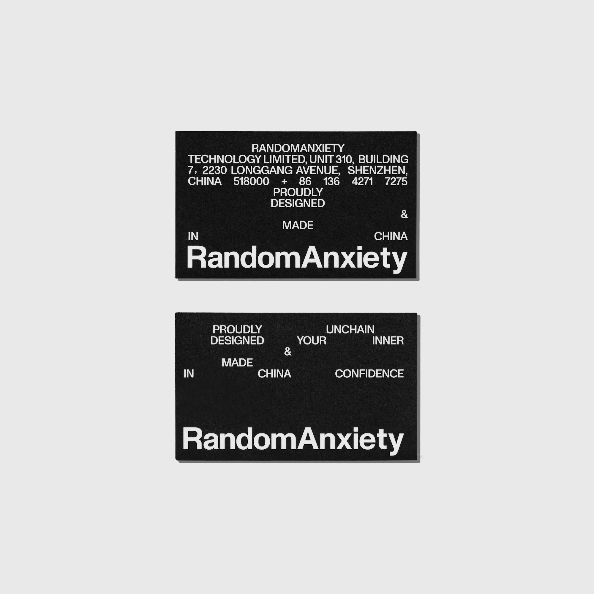 Two black cards with white text displaying company information and the brand name RandomAnxiety against a gray background.