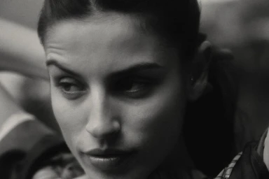 Close-up monochrome portrait of a woman with dark hair looking aside in a campaign for Brunello Cucinelli.